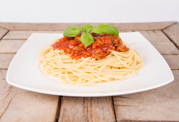 Spaghetti bolognese on a plate on a wooden background