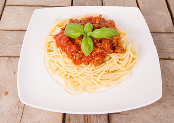 Spaghetti bolognese on a plate on a wooden background