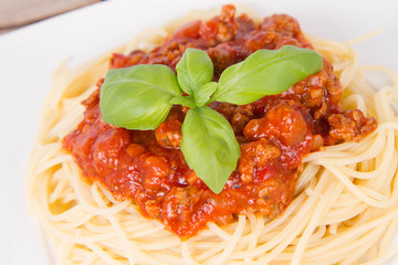 Spaghetti bolognese on a plate on a wooden background