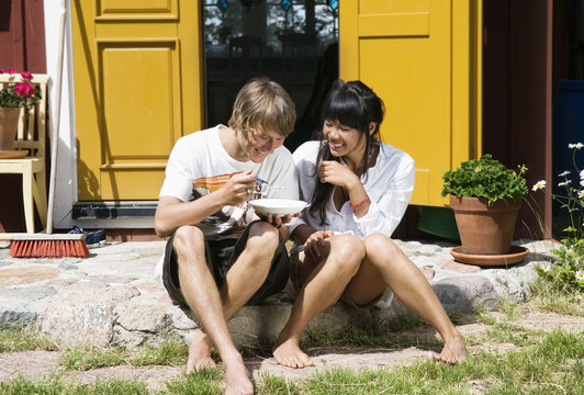 Guy and girl sitting outside dorr