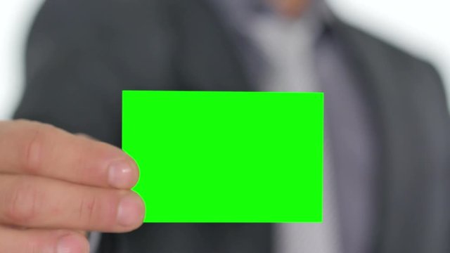 male hand giving a green business card to the camera pre keyed