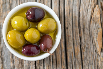 olives in a bowl on wooden surface