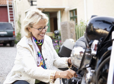 Woman tinker with motorcycle