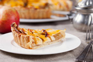 Slice of apple tart on a white plate Traditional holiday dessert Wooden rustic background