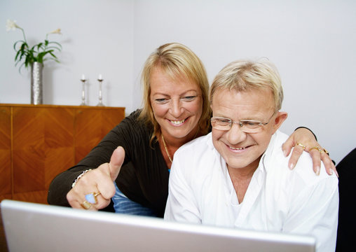 Woman doing tumbs up by computer