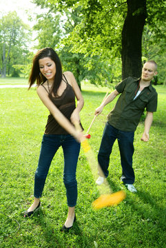Girl hitting a ball in croquet in anger