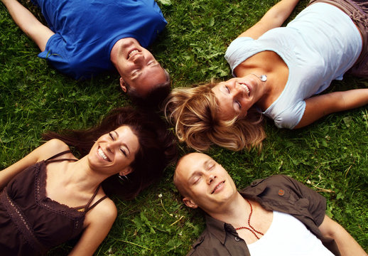 Four friends lying in the grass
