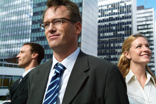 Three businessmen in front of high-rise building