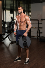 Obraz na płótnie Canvas Bodybuilder Holding Weights In Hand