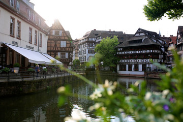 Fototapeta na wymiar Summer day in Strasbourg. Medieval cityscape of Rhineland black and white timber-framed buildings in the Petite-France district alongside the river Ill on sunny day - France, Alsace region.