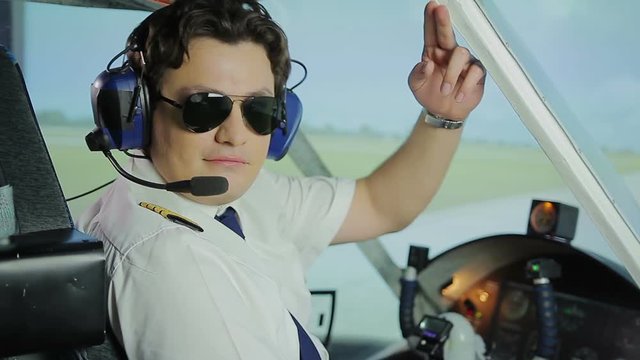 Professional aviator making thumbs up sign for camera, reliable airline services