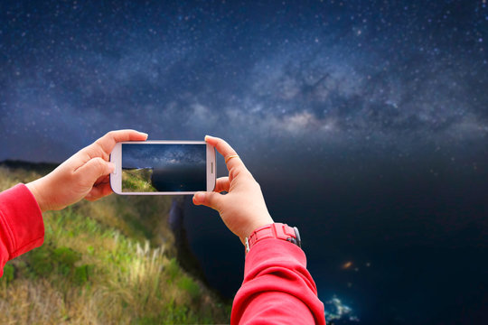 Smartphone photographing milky way galaxy with stars and space dust in the universe at night time, Phu Chi Fah, Chiang Rai Province, Thailand