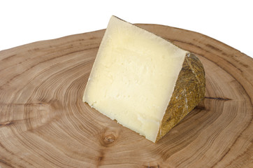 Piece of sheep milk cheese over elm wood.