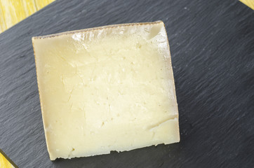 Piece of sheep milk cheese over slate plate