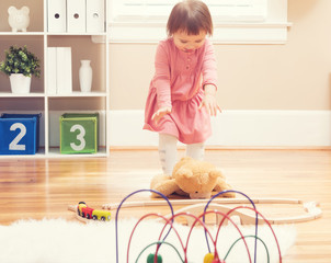 Happy toddler girl playing with toys
