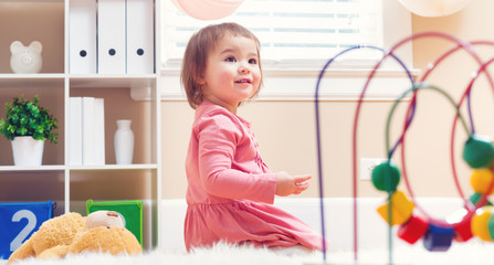 Happy toddler girl playing with toys