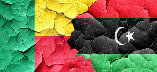 Benin flag with Libya flag on a grunge cracked wall