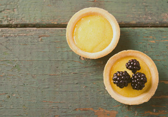 Homemade round tartlets with lemon curd and fresh blackberries