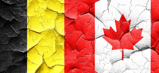 Belgium flag with Canada flag on a grunge cracked wall
