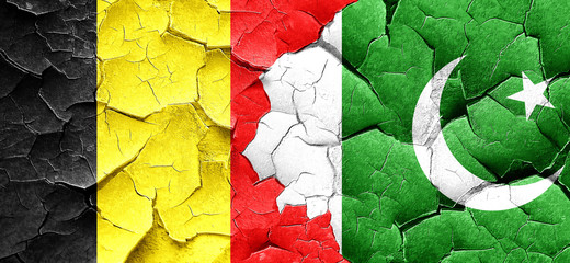 Belgium flag with Pakistan flag on a grunge cracked wall