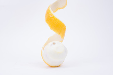 Yellow lemon with peeled skin on white background.