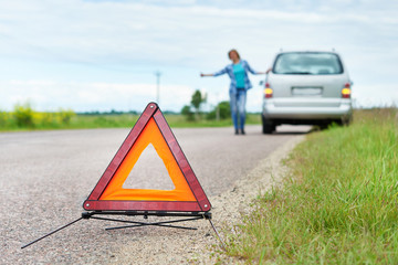 Emergency sign and woman waiting help near her car