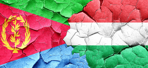 Eritrea flag with Hungary flag on a grunge cracked wall