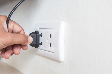 Unplug or plugged in concept,hand holding and pull electric plug