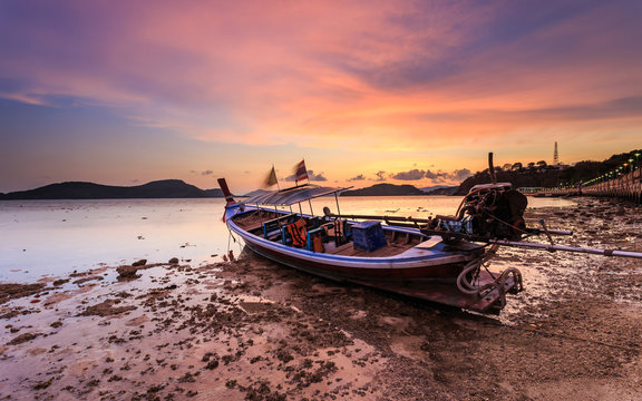Traditional Thai longtail boat at sunrise beach in Phuket