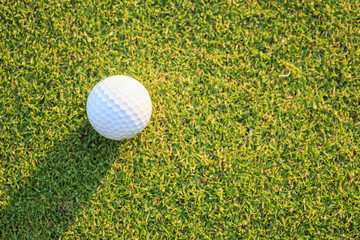 Golf ball on green grass in course