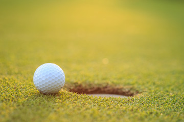 Golf ball on lip of cup  in course