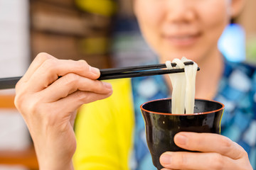 using chopstick eat noodle