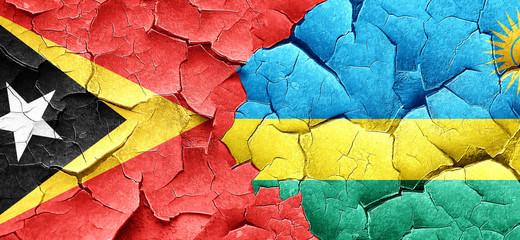 east timor flag with rwanda flag on a grunge cracked wall