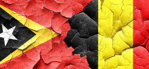 east timor flag with Belgium flag on a grunge cracked wall