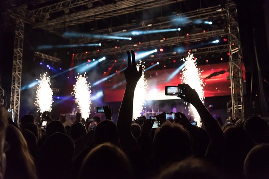 Rock Concert, Silhouettes Of Happy People Raising Up Hands In Front Of Bright Stage Lights. Space In Top Side.