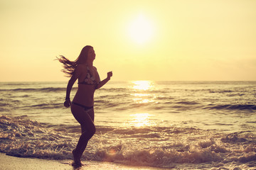 Fototapeta na wymiar Silhouette of carefree woman on the beach