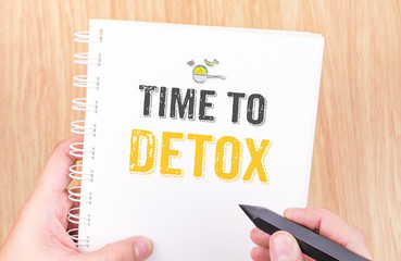 Time to detox word on white ring binder notebook with hand holdi