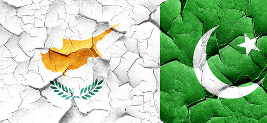 Cyprus flag with Pakistan flag on a grunge cracked wall