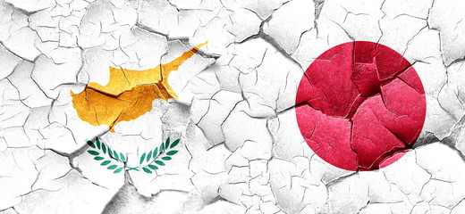 Cyprus flag with Japan flag on a grunge cracked wall