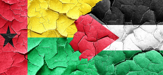 Guinea bissau flag with Palestine flag on a grunge cracked wall