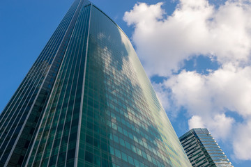 Fototapeta na wymiar Steel and glass corporate buildings reflect the sky and clouds,