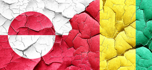 greenland flag with Guinea flag on a grunge cracked wall
