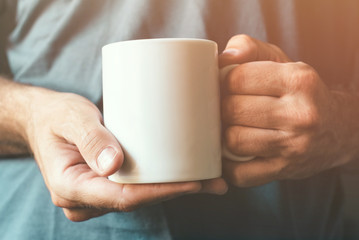 White coffee cup in male hands