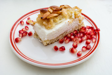 Cheesecake with crumbled peanuts and sugar and pomegranate seeds
