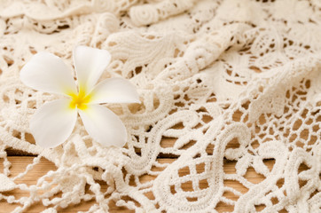 Flower with lace on wooden background. Place for text.