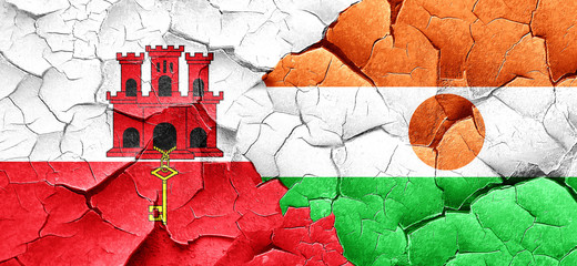 gibraltar flag with Niger flag on a grunge cracked wall