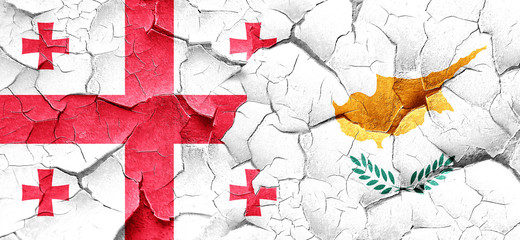 Georgia flag with Cyprus flag on a grunge cracked wall