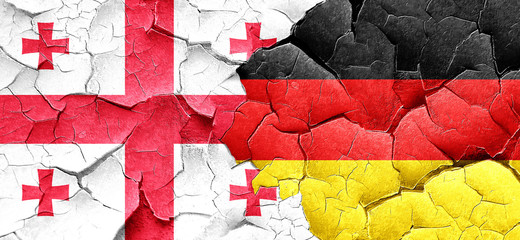 Georgia flag with Germany flag on a grunge cracked wall