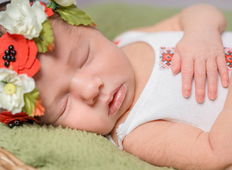 Obraz na płótnie Canvas newborn girl in Ukrainian costume sleeping close-up