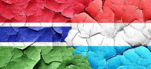 Gambia flag with Luxembourg flag on a grunge cracked wall